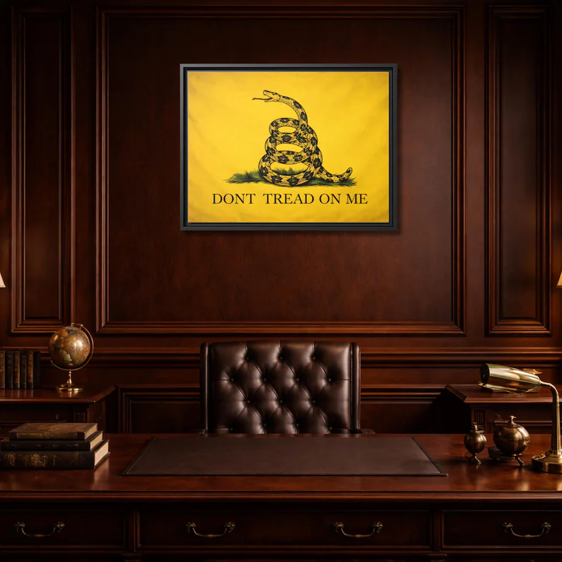 Close-up of the Gadsden Flag 'Don't Tread on Me' framed canvas on a rich mahogany paneled wall above an executive desk