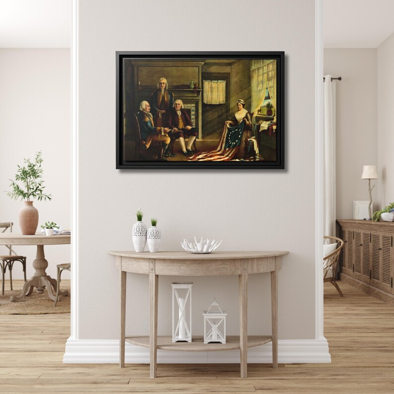 Birth of Our Flag framed canvas hung above a demilune console table in a bright entryway with white wainscoting and oak floors